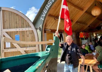 Formand Erik Toustrup med Dannebrog på plads i den flot vedligeholdte fladbåd ved en tidligere grundlovsdag hos Tversted Bjærgelaug. Foto: Arkiv.