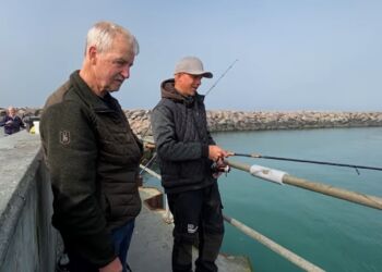 Vejrmanden Arvid Jacobsen i snak med lystfisker Rasmus Sørensen på havnen i Hirtshals. Foto: Arkiv.