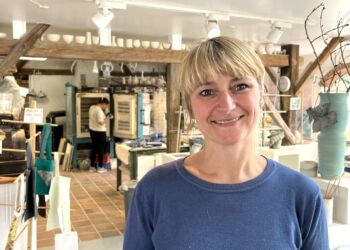 Vibe Falkenberg med Keramodas shop og keramikværksted som baggrund. Foto: Erhverv Hjørring.