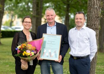 Malene Busk, regionsrådsmedlem og medlem af priskomiteen, overrækker pris og blomster til ledende overlæge Anders Kruse, Øjenafdelingen på Aalborg Universitetshospital og Klaus Larsen, direktør i Digitalisering og IT.