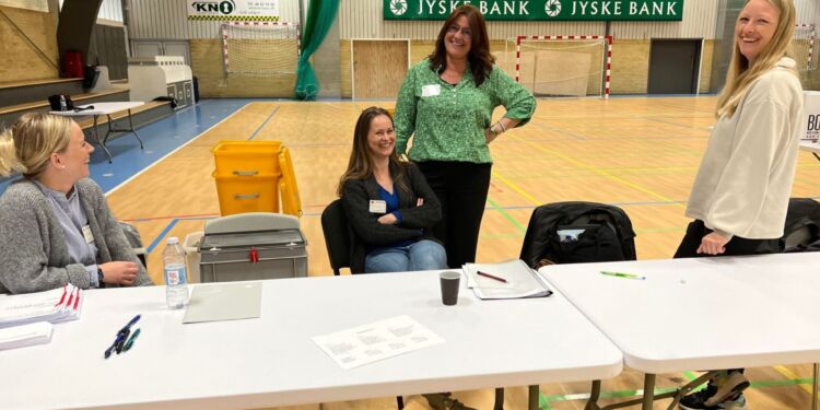 Valgstyrerformand Mette Jensen, som her ses stående bag Jeanette Nørager, mens det til venstre er Lena Bisgaard og til højre Ditte Kjøbsted, styrer stemmeafgivningens gang i Hirtshals Idrætscenter. Foto: Niels Skipper.