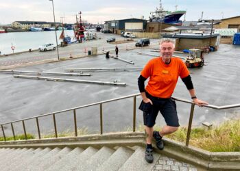 Claus Neve Olsen i orange trøje, der gør de frivillige let genkendelige til Musik Under Trappen. Foto: Niels Skipper.