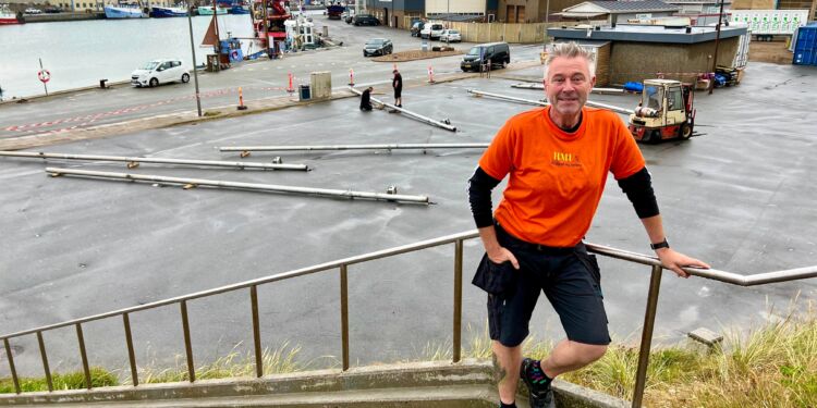 Claus Neve Olsen i orange trøje, der gør de frivillige let genkendelige til Musik Under Trappen. Foto: Niels Skipper.