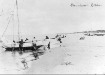 Fiskere i færd med at hale en båd i land ved stranden i Løkken, omkr. 1900, postkort.. Foto: VHM.