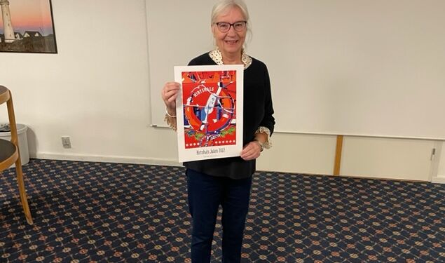 Kunstner Ninne Nielsen viser sin flotte juleplakat.