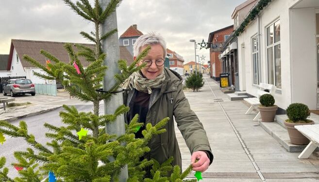 Formand Dorthe Schaltz pynter et af træerne hos Hirtshals Handel & Erhverv.