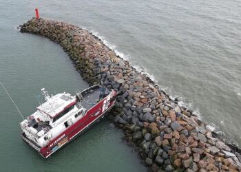 Skibet har siddet fast på molen siden onsdag middag med flere huller i skroget. Dronefoto: TV2 Nord.