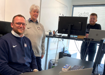 Dana Cups direktør, Jette Andersen, tager imod sin nye medarbejder, mens kollegaen, Jonas Menholt, ser til.