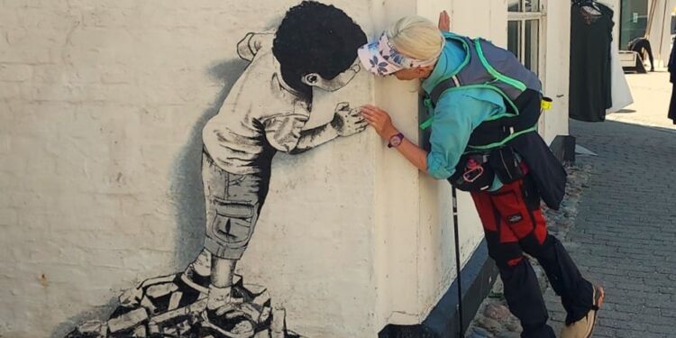 Birthe Nesgaard Johansen fra Vandrefuglens Univers kigger her omkring hjørner efter Street Art i Løkken. Foto: Privat.