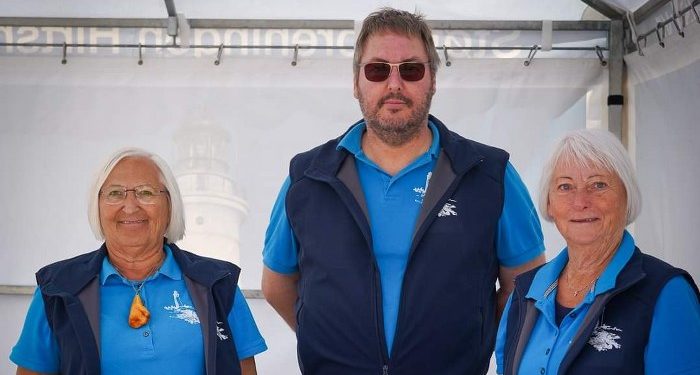 Her ses Peter Jensen, som er formand og sekretær i Støtteforeningen for Hirtshals Fyr, stående mellem Lillian (tv) og Hanna, ved Hirtshals Fiskefestival i 2023. Foto (arkiv)Arturs Pirazkov.