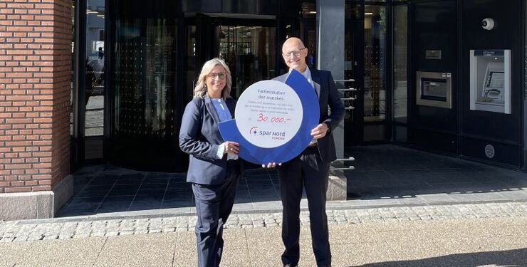Mads Pedersen fra Spar Nord overrækker check på 30.000 kr. til Rikke Ejsenhardt fra Hjørring Handel.