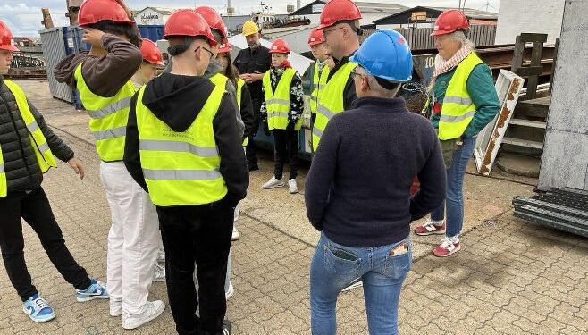Brian Sproegel (med gul hjelm) fortæller eleverne om Vestkajens Maskinværksted. Foto: Niels Chr. Jakobsen.