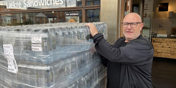 Butiksbestyrer Jan Hansen med det krystalklare vand fra fjeldet Kirvi på Færøerne. Foto: Niels Skipper.