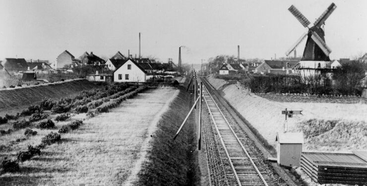 Fra Johanne Breunings erindringsfortælling om en barndom i Bredfald Mølle ved Frederikshavnsvej. Billedet er taget ind over Hjørring fra øst. Midt i billedet er statsbanen. Til højre for banen ses Bredfald Mølle. Fabriksskorstene er fra venstre gasværket, andelssvineslagteriet (uden røg), Arbejdernes Fællesbageri (med røg) og mejeriet Katrinelund. Foto: Historisk Arkiv, Vendsyssel Historiske Museum.