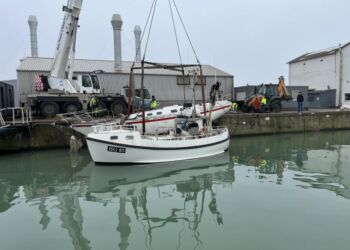 Sejlbåden hæves ved Slæbestedet. Til højre for sejlbåden ses indehaveren i snak med Andreas Christiansen, som er Head of Port Operations & Pilot hos Hirtshals Havn. Foto: Niels Skipper.