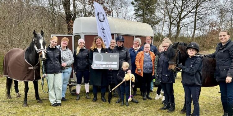 Filialdirektør Betina D. Jensen overrækker en check med 20.000 kroner fra Nordea Fonden til Soldalens Rideklub. Foto: Privat.