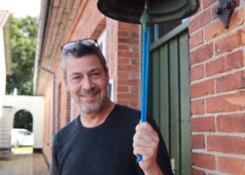 Lars Vestergaard ved klokken på Vrå Højskole. Foto: Malte Westergaard..