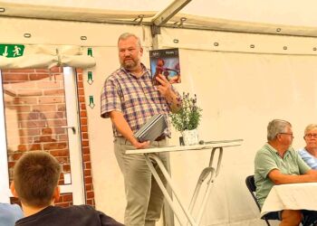 Peter Houen Sørensen fra bestyrelsen med den bog, som i 30 eksemplarer gavmildt blev givet til Sindal Skole.