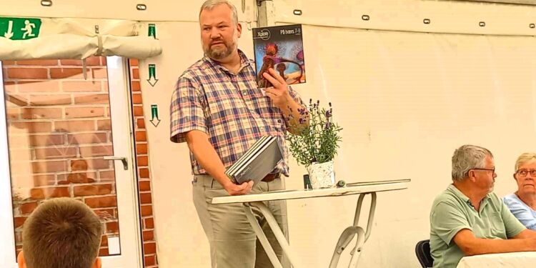 Peter Houen Sørensen fra bestyrelsen med den bog, som i 30 eksemplarer gavmildt blev givet til Sindal Skole.