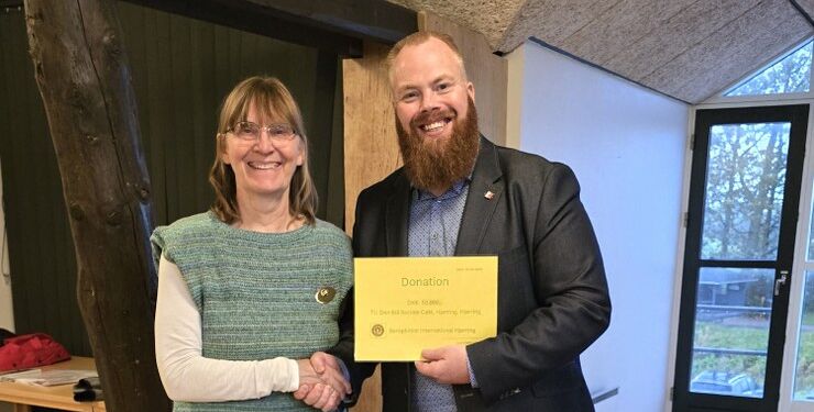 Karin Møller Larsen præsident for Hjørring klubben havde penge med til socialrådgiver Martin Mølbak Jensen fra Den Blå Sociale Café. Privatfoto
