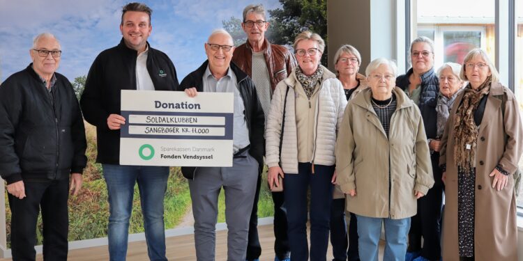 Afdelingsdirektør Mads Nielsen fra Sparekassen Danmark i Sindal overrækker donationen på 11.000 kroner til John Schou fra Soldal Klubben.
De øvrige på billedet er Søren, Kim, Lisbeth, Anni, Connie, Gitte, Ulla og Dorthe.