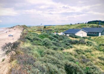Der er stadig en del klit tilbage mellem stranden og bygningerne. Den hvide er den nuværende toiletbygning ved siden af Tversted Bjærgelaugs Bådhuset. Foto: Palle W. Nielsen