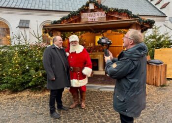 Et hyggeligt og venskabeligt møde imellem julemanden og biskop Thomas Reinholdt Rasmussens indgår i den traditionelle julehilsen fra Aalborg Stift. Til højre for biskoppen og julemanden ses fotograf Hans Ravn.