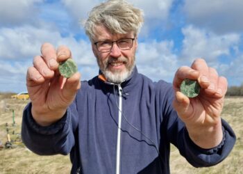 Detektorfører Øystein Larsen med to nyfundne romerske sestertser. Foto: Vendsyssel Historiske Museum.