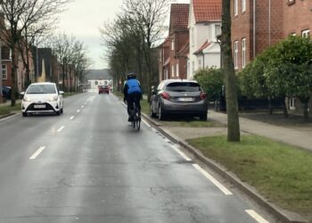 Frilandsvej i Hjørring med lidt plads til cyklister. Rabatten med græs og en parkeret bil plus fortovet svarer cirka til bredden på promenaden på Tannisbugtvej i Tversted. Vejen på billedet svarer cirka til den planlagte bredde på Tannisbugtvej. Foto. Palle W. Nielsen