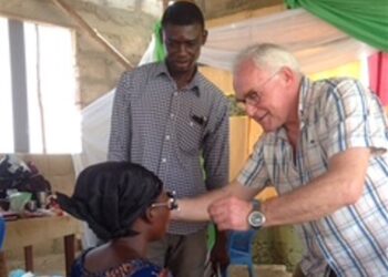 Flemming Jensen i gang med at tilpasse et par briller ved udlevering i Afrika. Foto: Privat.