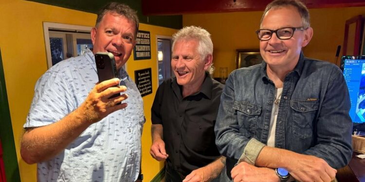 Jan Gaardbo Christensen med Jan Olesen på mobilen får hilst på musikerne Chris Borup og Brian Bruun. Foto: Niels Skipper.