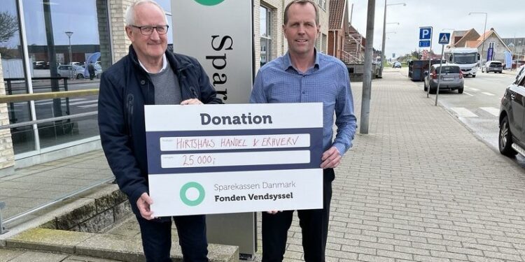 Handelschef Per Martensen modtager checken fra filialdirektør René Jensen foran Sparekassen Danmark i Hirtshals. Foto: Privat.