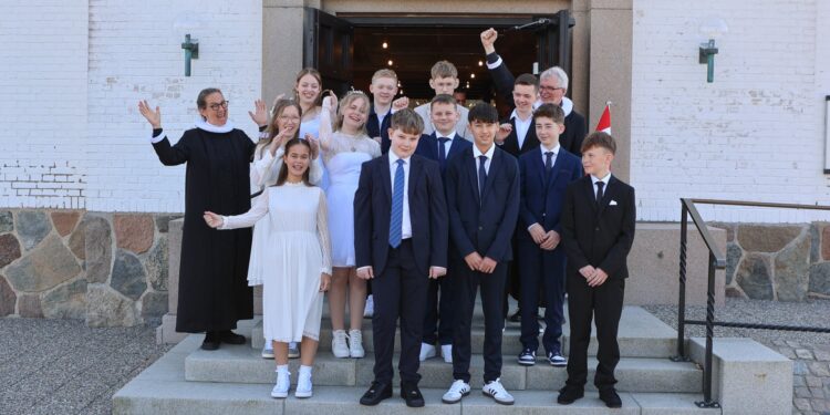 Søndagens glade konfirmander og de to præster foran Hirtshals Kirke. Foto: Henrik Risager.