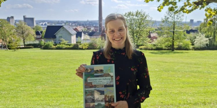Forfatter Line Votborg Laibjørn med bogen om Aalborg. Foto: Privat.