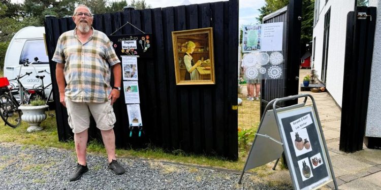 Ejner Jensen ses her ved indgangen til det store junsthåndværkermarked, som han for andet år arrangerer på matriklen i Nr. Tornby. Foto: Niels Skipper.