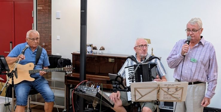 Formanden for Dame- og Herreklubben Willy Schneider byder velkommen til en hyggelig sangeftermiddag.