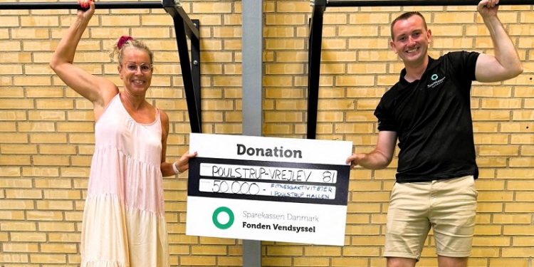 Her overrækker Kasper Søborg Nielsen fra Sparekassen Danmarks afdeling i Vrå donationen til instruktør Karina Kristensen fra PV81’s fitnessafdeling. Foto: Privat.