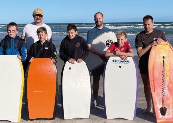 Billedet viser de konfirmander, der var med til sognepræst Johan Hermann Rumps ”sensommer surf-start” på stranden og i det lave vand ved Tversted Strand. Forældre bakkede flot op, og billedet skyldes Tversted-Graverne 2025 (GHS).
