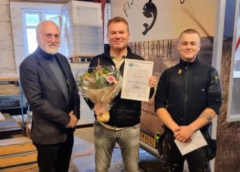 Direktør Neil Jacobsen fra EUC Nord overrakte blomster og diplom til direktør Henrik Fjordbak og lille gave til tømrerlærling Sebastian Dahl Sørensen. Foto: EUC Nord.