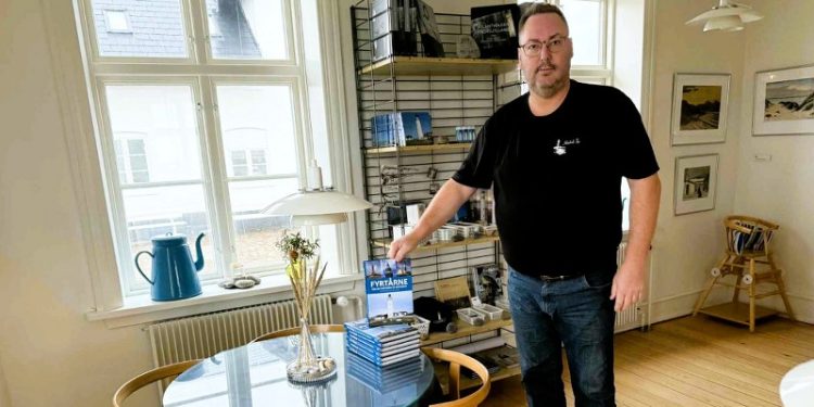 Peter Jensen, som er formand i Støtteforeningen Hirtshals Fyr, ses her i Kaffestuen med bogen Fyrtårne - Mellem Nordsøen og Østersøen. Foto (arkiv): Niels Skipper.