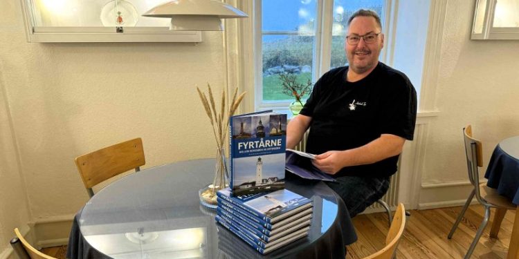 Peter Jensen, som er formand i Støtteforeningen Hirtshals Fyr, sidder her i Kaffestuen med bogen Fyrtårne - Mellem Nordsøen og Østersøen. Foto: Niels Skipper.