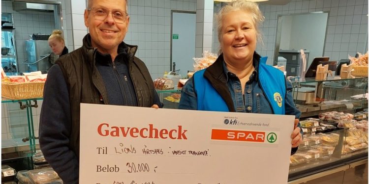 Købmand René Ejstrup Larsen giver her gavechecken på kr. 30.000 præsidenten for Lions Tanja Nielsen. Foto: Lions.