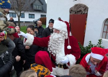 Julemanden deler slikposer ud til børnene.