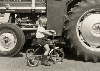 Søren på sin trehjulede cykel foran farens nye Massey Ferguson 135. Foto: Privat.