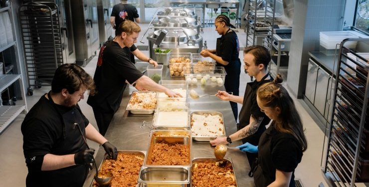 Kokke, elever og udsatte unge arbejder hver dag side om side i JunkFoods køkken på Frederiksberg, hvor de med udgangspunkt i oveskudsvarer laver de 1.000 måltider, som JunkFood dagligt serverer for gadens folk landet over. Foto: Daniel Jensen 24Copenhagen