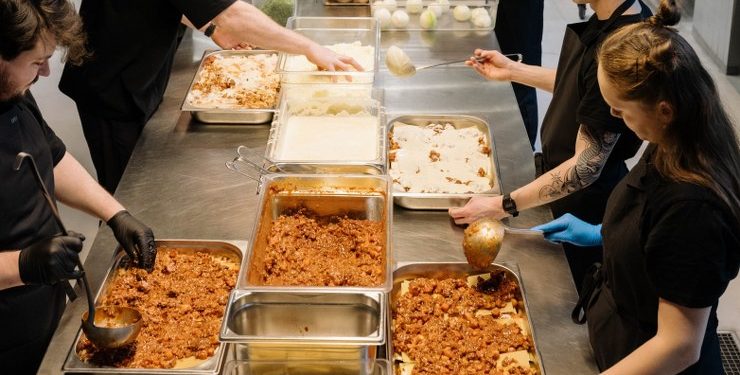 Kokke, elever og udsatte unge arbejder hver dag side om side i JunkFoods køkken på Frederiksberg, hvor de med udgangspunkt i overskudsvarer laver de 1.000 måltider, som JunkFood dagligt serverer for gadens folk landet over. Foto: Daniel Jensen 24Copenhagen