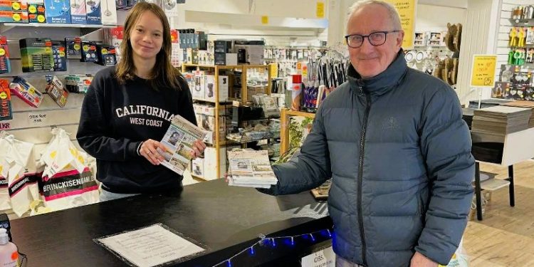 Anne hos Brinck Isenkram i Nørregade tager imod en stak bykort fra Per Martensen. Foto: Privat.