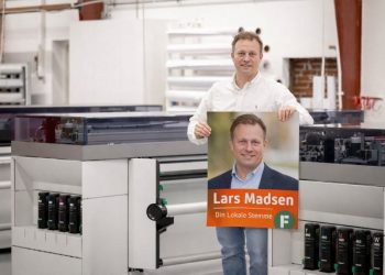 Indehaver Kristian Klokkerholm Kristensen med en valgplakat hos Egotag. Foto: Privat.