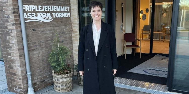 Anne Honoré Østergaard (V) ved indgangen til Friplejehjemmet Asbjørn i Tornby. Foto: Niels Chr. Jakobsen.