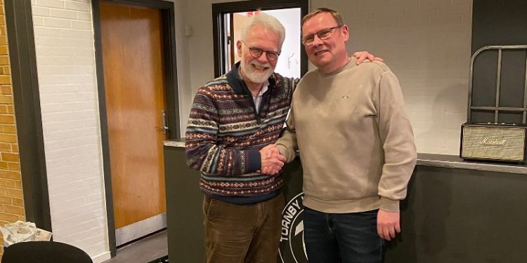 Afgående formand Henrik Willadsen lykønsker afløseren Mads Kjær. Foto: TIF.